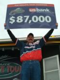 Pro Dean Arnoldussen displays his first-place check for $87,000.