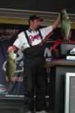 Chris Weaver holds one big bass while placing another on the scales. His 22-pound, 11-ounce total landed him in third on the co-angler side.