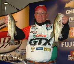 Co-angler leader Mark Phillips shows off two bass that he caught Friday on Lake Travis. 