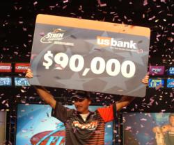 Pro winner Mike Jackson holds up his first-place check worth $90,000. 