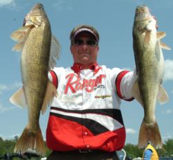Pro winner Scott Steil holds up two giant Cass Lake walleyes he caught on day four. 