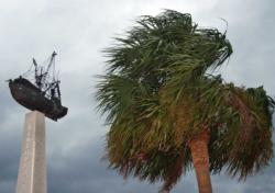 Palm fronds next to a shrimping industry monument at the Fernandina waterfront whip wildly in the wind.