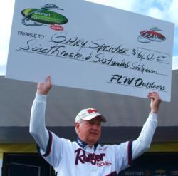 Co-angler champion Gary Speicher holds up his check for winning the FLW Walleye Tour event on the Mississippi River.