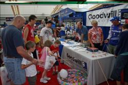 At left, Tim Kist helps his stepson Joshua Bass fish for a prize at the Goodwill booth.