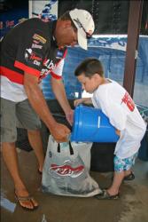 Day one pro leader George Jeane Jr gets a bucket of Rejuvenade water on his fish.