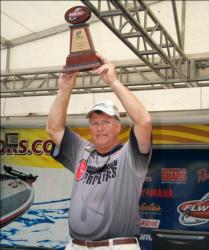 Co-angler champion Mike Devere holds his trophy high over his head.