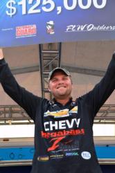 Chevy pro Luke Clausen of Otis Orchards, Wash., holds up his first-place check after capturing the tournament title at the FLW Tour Potomac River event.