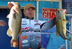 Third-place pro Troy Morrow holds up his two biggest bass from day two on Lake Guntersville.