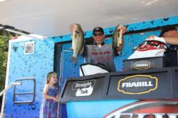 Third-place pro Benjamin Byrd shows off his day-three catch while daughter Chloe looks on with pride.