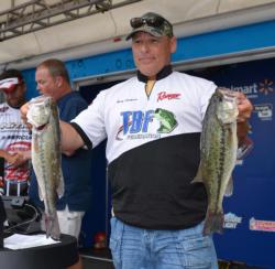 Second-place co-angler Rick Harkness holds up his two biggest bass from day two.