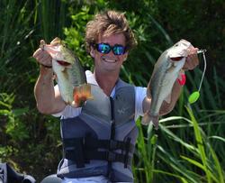 Co-angler Theo Corcoran holds up two giant Red River largemouths Thursday afternoon. 