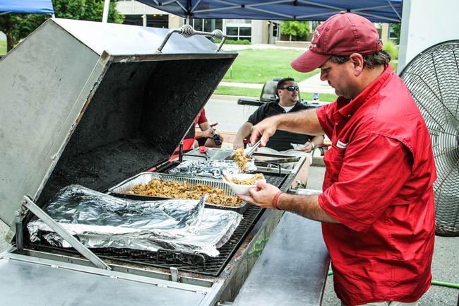 Pitmaster John O. Brown Jr. serves up some pulled pork at Southern Que-N-Stew.