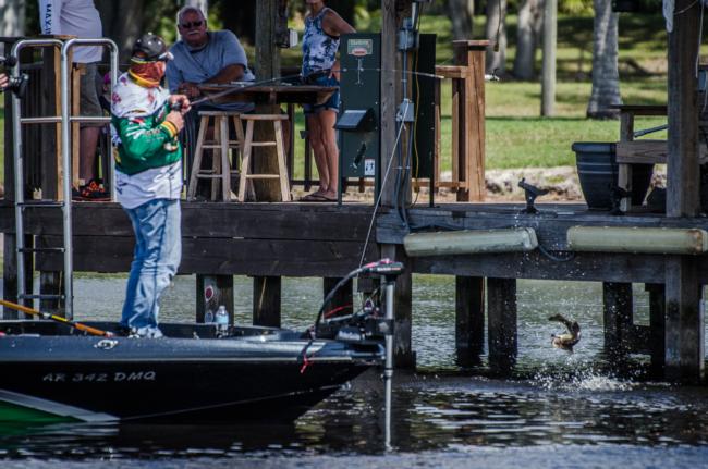 Quaker State pro Scott Canterbury caught the biggest limit of day four after making a surprise run into Tiger Lake. Here he tussles with a bass as the dock's owners look on. 